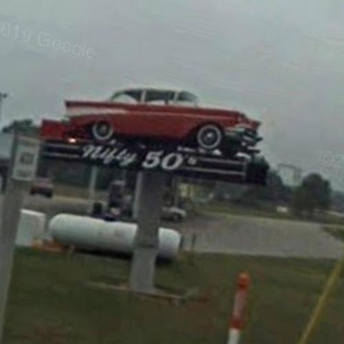 1957 Chevy on a sign pole in Manistique, MI (Google Maps)
